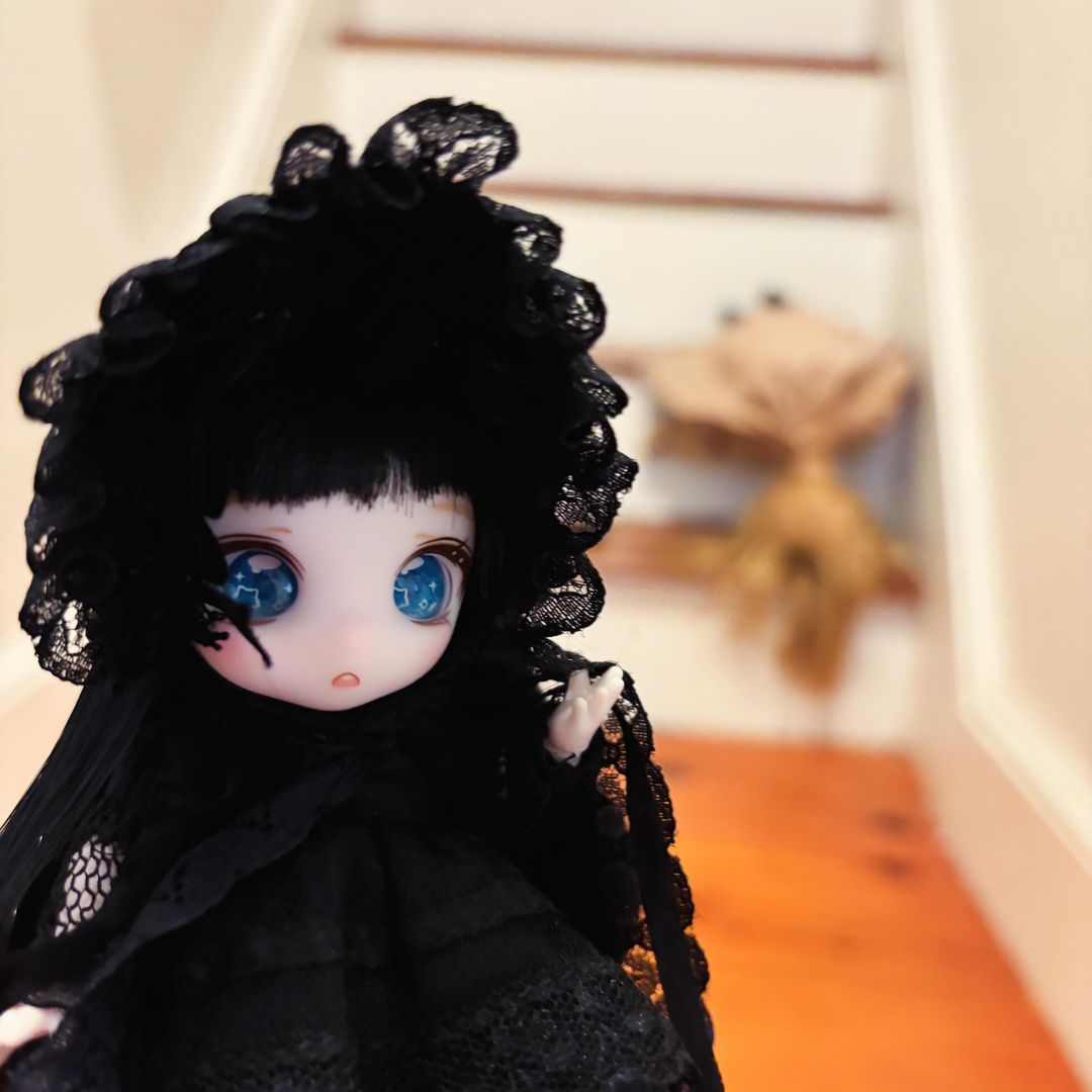 12cm BJD girl with blue eyes and long straight black hair wearing a lacy Gothic Lolita dress and hat